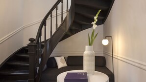 A modern interior with a staircase, a round table with a vase and book, and a sofa with cushions. - Beautiful Acropolis Villa 3BR 9ppl 10 minutes Metro&Museum (Athina)