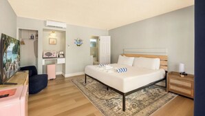 Une chambre à coucher comprenant un lit, une table de chevet, une commode et un bureau avec une chaise.