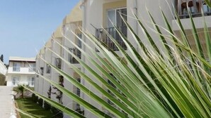 Uma fileira de edifícios modernos e brancos com varandas, provavelmente parte de um hotel ou complexo de apartamentos.