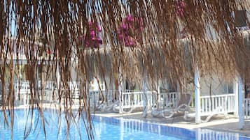 Una piscina al aire libre de temporada, sombrillas, tumbonas