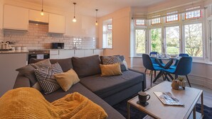 Ein modernes Wohnzimmer mit Sofa, Couchtisch und Essbereich.