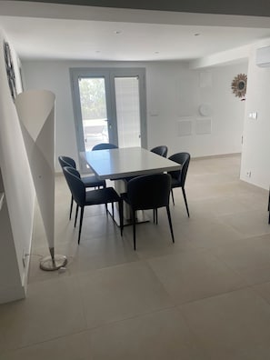 A modern dining area with a rectangular table and six chairs.