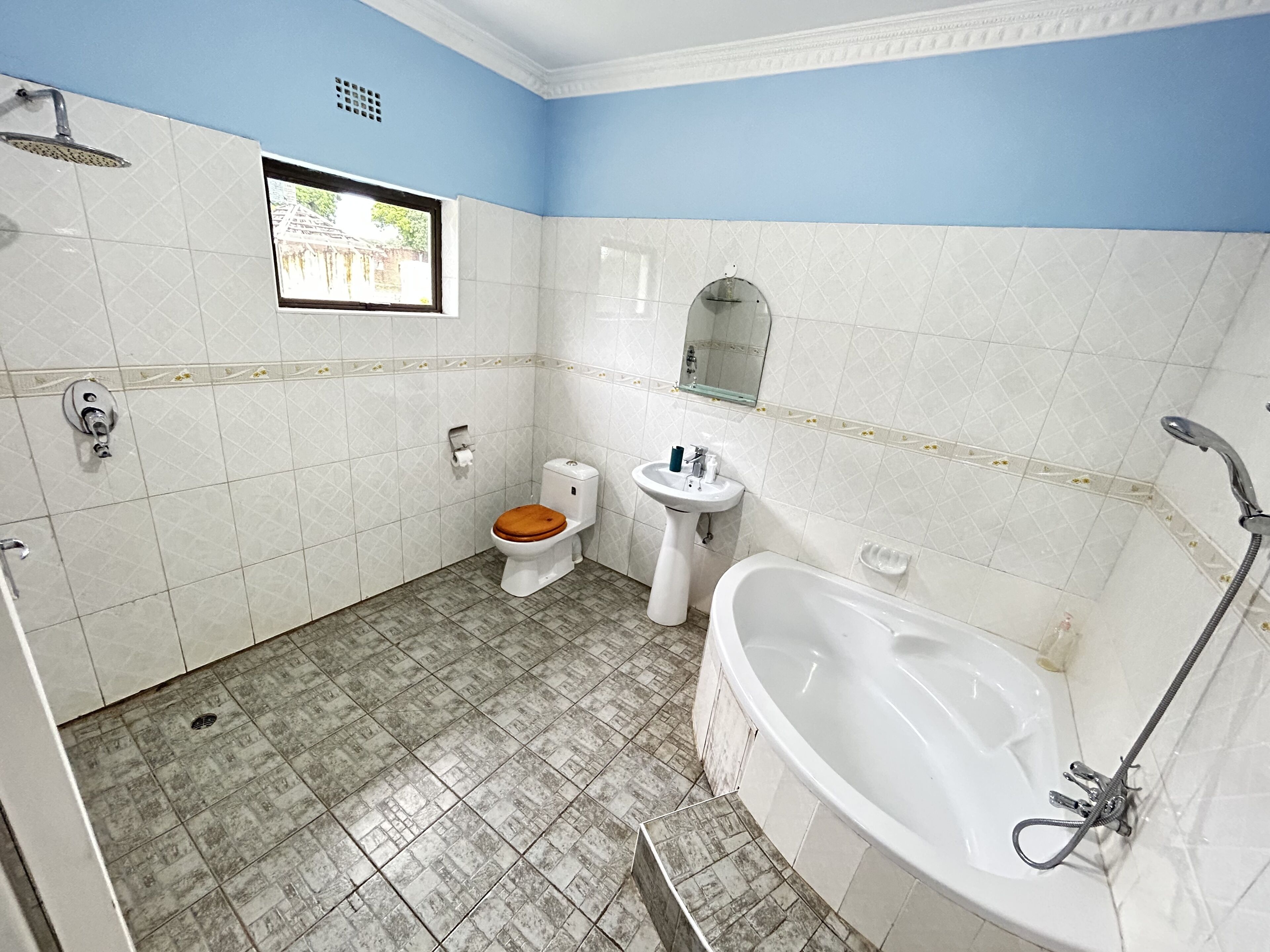 A bathroom with a toilet, sink, bathtub, and shower.