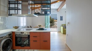 Uma cozinha moderna com forno embutido, máquina de lavar roupa e espaço de jantar com mesa e cadeiras.