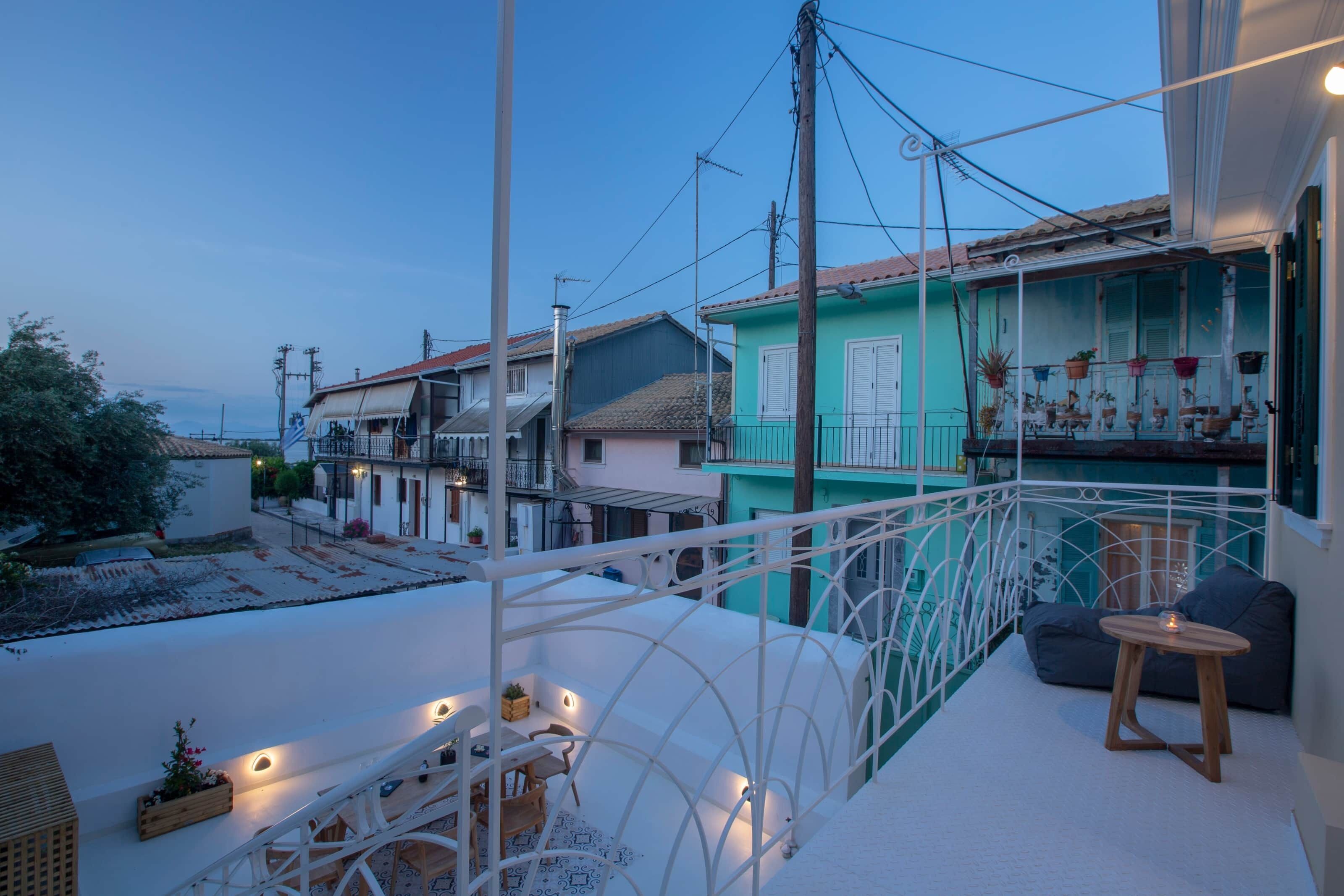 Un balcone con ringhiera bianca, un tavolino e una sedia.