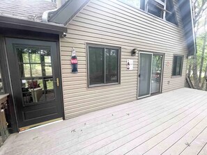 A house with a front door, a deck, and two windows.