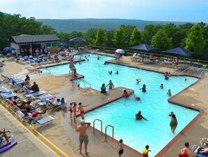 A swimming pool area with multiple pools, sun loungers, and umbrellas. - Pocono Cabin w/ Jacuzzi, W&D, and Indoor Pools (Bushkill)