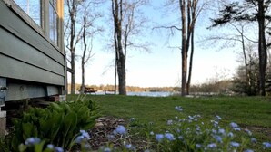 Un edificio de madera con un patio césped y un lago al fondo.