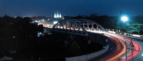 A nighttime view of a bridge with light trails from moving vehicles.