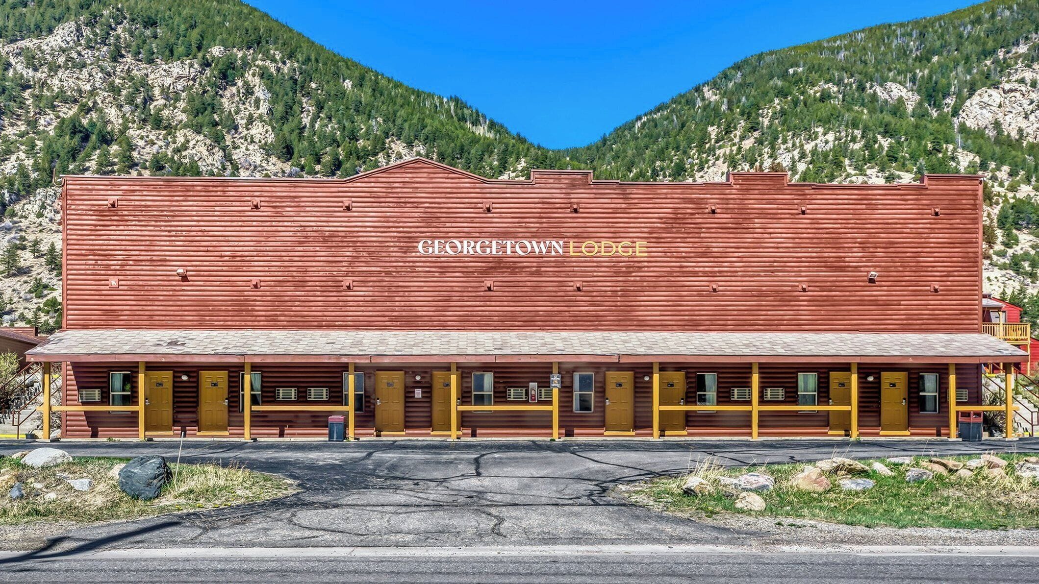 A large red building with 'GEORGETOWN LODGE' written on the side, featuring a long front with multiple doors and windows.