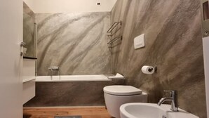 A modern bathroom with a shower, toilet, and sink. - DV Garda Suite 55.0 (Campione del garda)