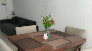 A dining table with a vase of flowers, surrounded by four chairs. - Autódromo Apartment, Foro Solo, Cdmx Airport (Ciudad de México)