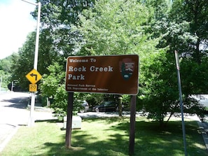 A welcome sign for Rock Creek Park, indicating a 20 mph speed limit and the National Park Service affiliation.
