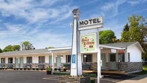 A motel with a prominent sign for 'The Apple Blossom Inn'.