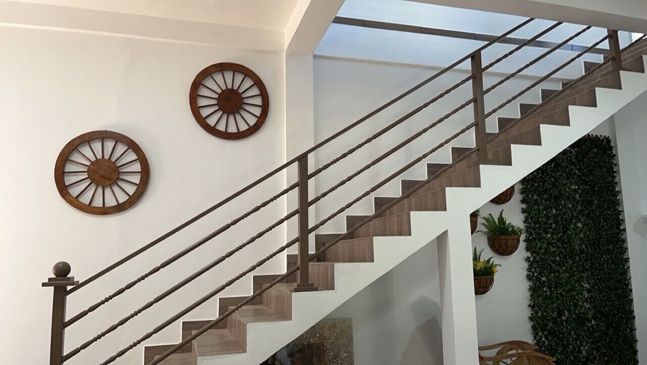 Eine Treppe mit Holzstufen und Metallgeländern, gesäumt von an Wänden befestigten Zierrädern.