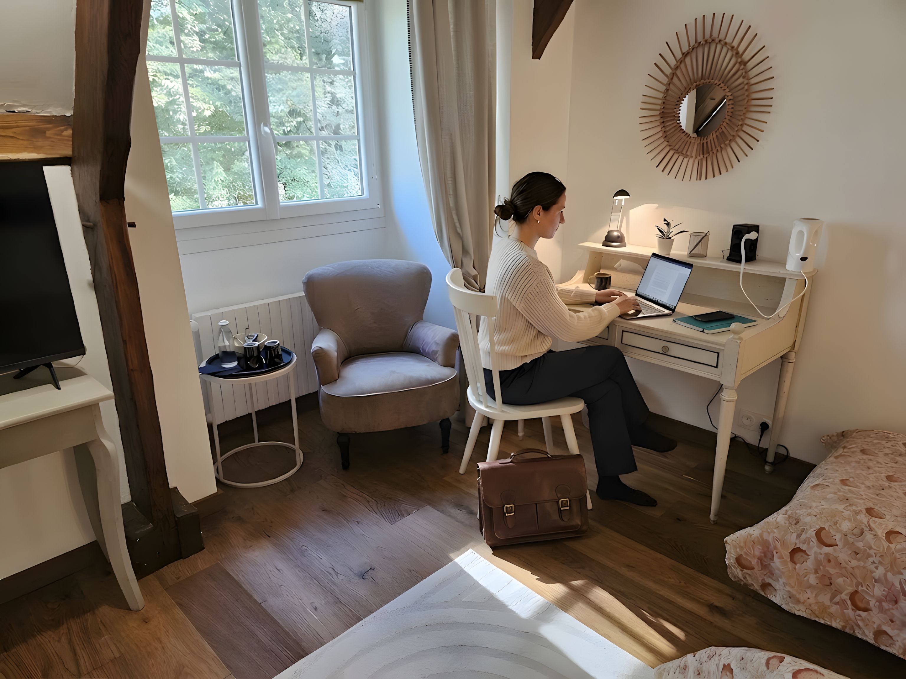 A room with a desk, chair, laptop, and a television.