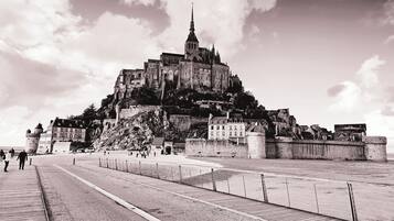 Un château historique, doté d’une tour imposante, situé sur une colline surplombant une région côtière.