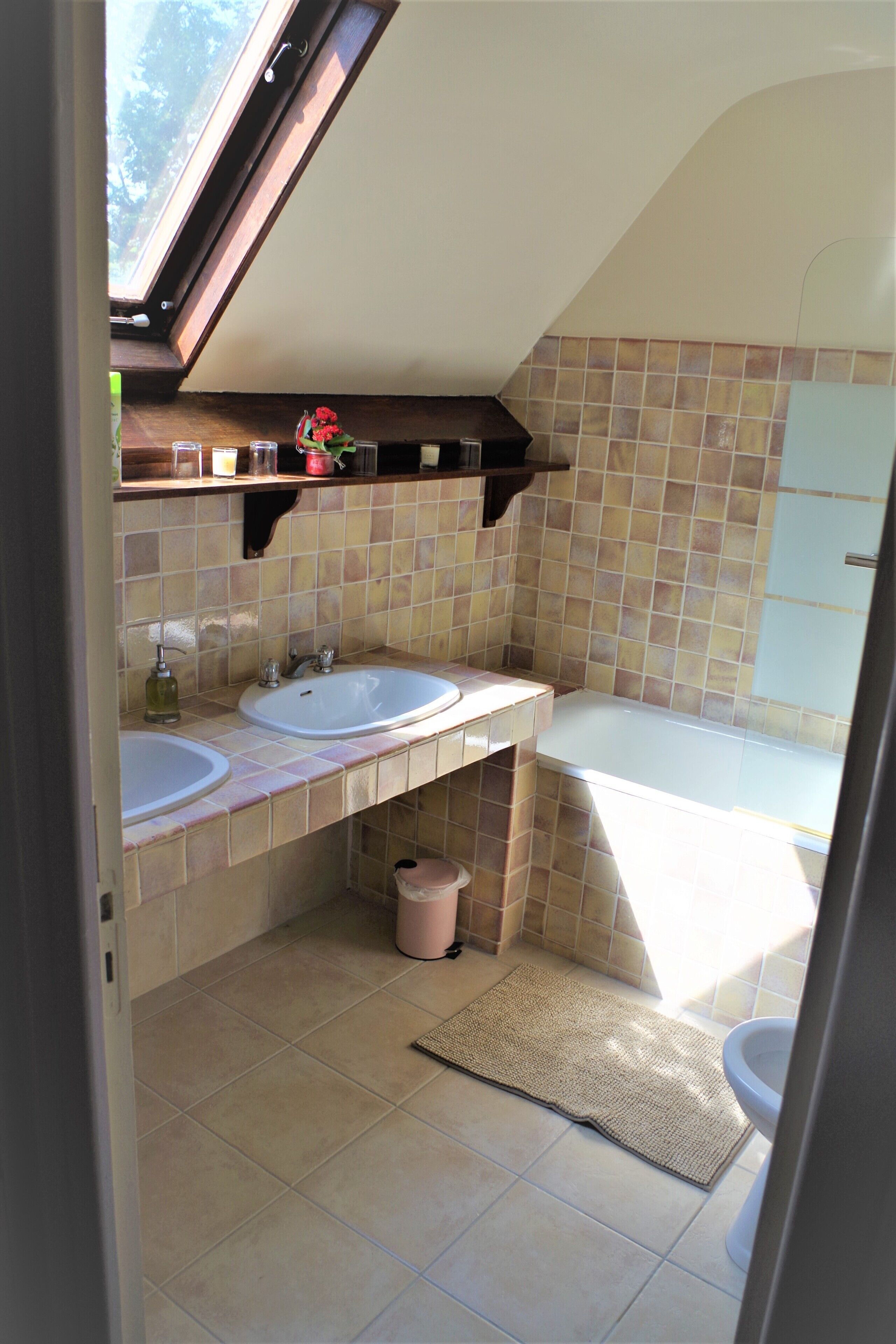 A bathroom with two sinks, a bathtub, and a window.