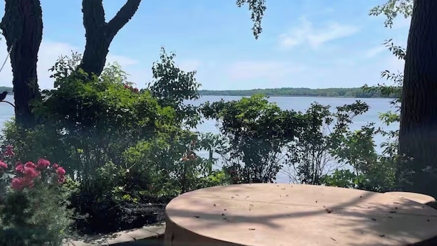 A view of a lake with trees and a wooden structure in the foreground. - Sunset River Cottage (Elkton)