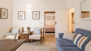 A living room with a sofa, chairs, a coffee table, and framed artwork on the walls. - Appartamenti Anguria Toscana Two-bedroom (Sinalunga)