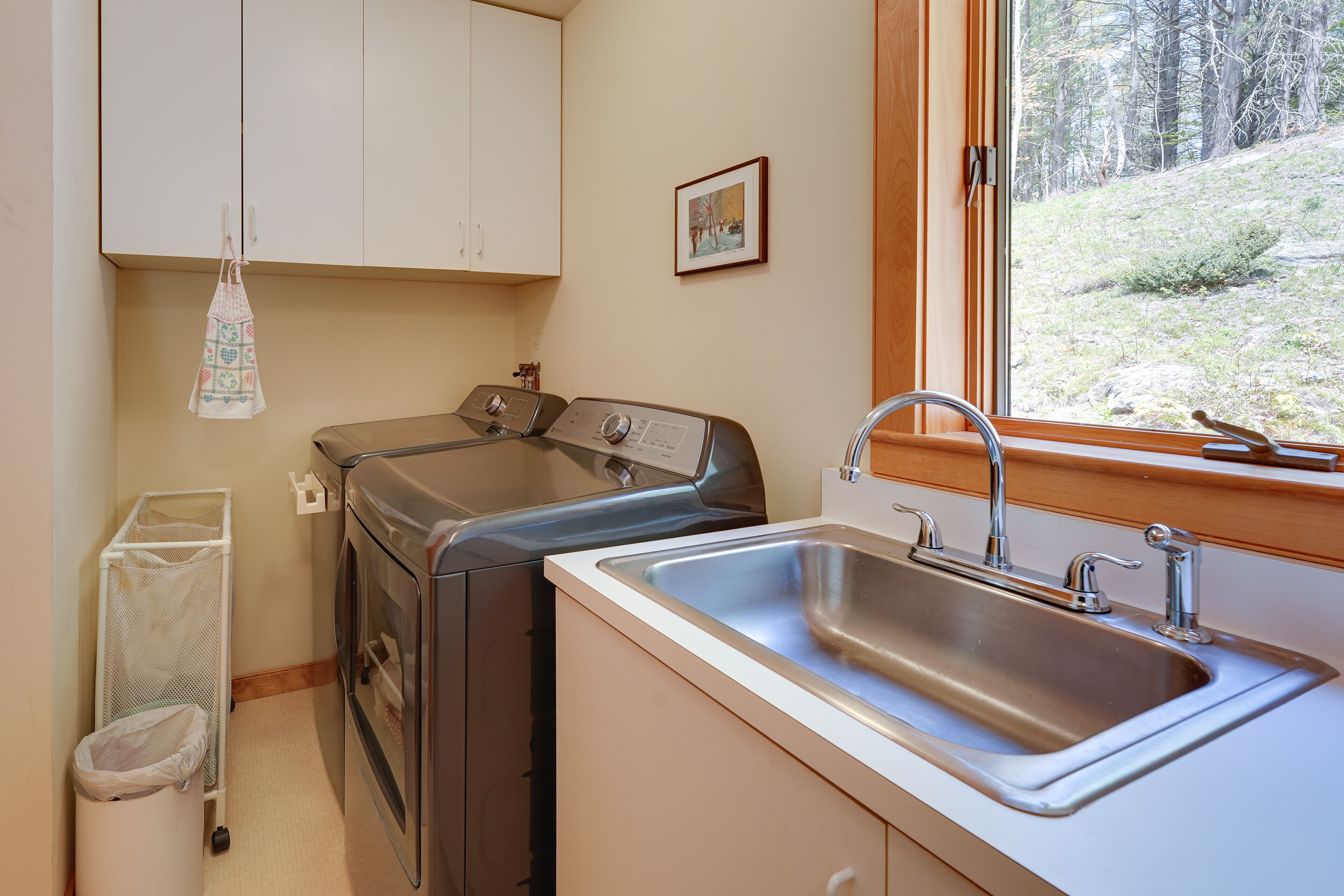 A compact kitchen with a stainless steel sink, a built-in oven, and a drying rack.