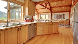 Une cuisine spacieuse avec des meubles en bois, un grand îlot central et une vue sur l’extérieur.