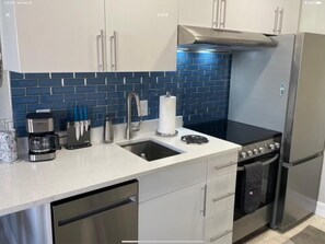 A modern kitchen with stainless steel appliances, a double sink, and a dishwasher. - The Turtle Nest 6 in Fort Myers Beach (Fort Myers Beach)