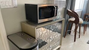 A kitchenette with a microwave, a trash bin, and a cabinet with drawers. - The Turtle Nest 6 in Fort Myers Beach (Fort Myers Beach)