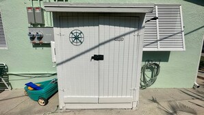 Une boîte de services publics ornée d’un logo circulaire, d’une enseigne indiquant « LAUNDRY » et d’un câble enroulé à proximité.