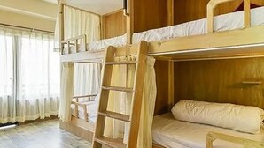 A bunk bed room with a wooden ladder and a window with curtains. - VT SKY SHIP HOTEL (Vientiane)