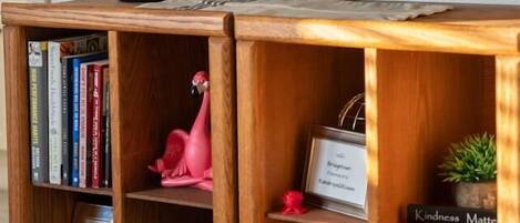 Un meuble de rangement en bois contenant un téléviseur à écran plat, des livres, des objets décoratifs et une petite plante.