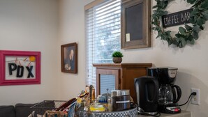 A kitchen area with a coffee maker, a kettle, a tray with food items, a framed artwork, and a sign reading "Coffee Bar". - Book NOW for Summer Fun! - Perfect for family! - Fully Loaded! - Fire Pit! (Portland)