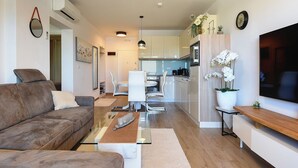 A modern living room with a sofa, coffee table, and TV stand. - Modern apartment with sea view (Medulin)
