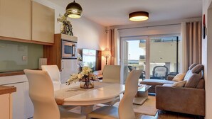A modern living room with a dining area, a sofa, and a TV. - Modern apartment with sea view (Medulin)