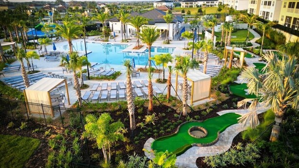 A resort with a large swimming pool, palm trees, and a golf course. - Disney Dream House, Themed Rooms Pool Arcade BBQ! (Four Corners)