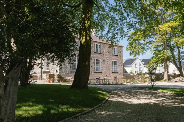 A stone building with multiple windows and a well-maintained lawn. - Stay Lagom Lodge (Ballycastle)
