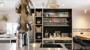 A modern kitchen with stainless steel appliances, a built-in oven, and a coffee station. - Stay Lagom Lodge (Ballycastle)