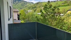 A balcony with a view of a green valley and distant houses, a clear sky, and a mountain in the background. - FP Appartements - Maisi 4, mountain view & summercard (Kaprun)