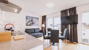 A modern kitchen with a granite countertop, a built-in stove, and a red faucet. - FP Appartements - Penthouse, Sun terrace & mountain View (Kaprun)
