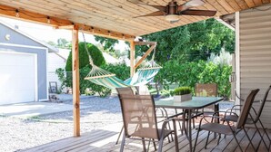 A covered patio with a table and chairs, a hammock, and a ceiling fan. - Artful Retreat Near GJs Main St: Dog-Friendly (Grand Junction)