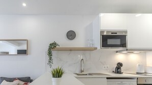 Une cuisine moderne avec un revêtement mural en marbre, un four encastré et un évier.