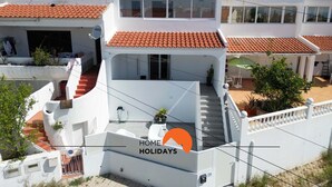 Un immeuble résidentiel à plusieurs étages, doté d’un toit recouvert de tuiles rouges, de balcons et d’un escalier menant aux étages supérieurs.