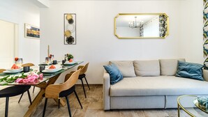 Et moderne spiseområde med et langt bord, stole og en sofa.