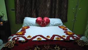 A bed with a heart-shaped pillow and a floral bedspread. - 	“Your Family’s Perfect Getaway by the Riverside!” (Mankulam)