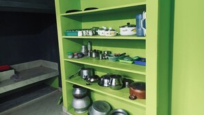 A green shelf unit with kitchen utensils and cookware. - 	“Your Family’s Perfect Getaway by the Riverside!” (Mankulam)