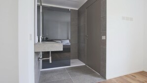 Uma casa de banho moderna com chuveiro, pia e sanita.