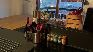 A kitchen with a Bosch induction cooktop, a window with a 'Congratulations' sign, and various kitchen utensils and containers. - Walking distance of all lifts/town for summer and winter fun! Sleeps 9 (Morzine)