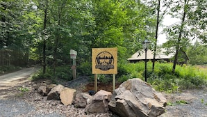 A gravel path with a wooden sign indicating 'Norwegian Woods' and a private property warning sign.