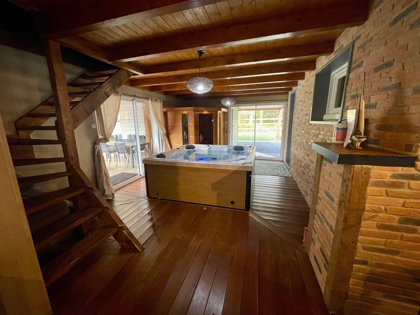 Ein gemütliches Zimmer mit einer Holztreppe, einer Whirlwanne und einer Backsteinwand.