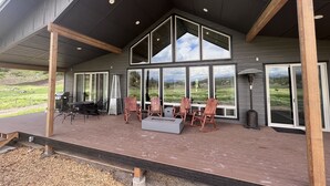 Un espace extérieur abrité comprenant un barbecue, des chaises et un foyer.